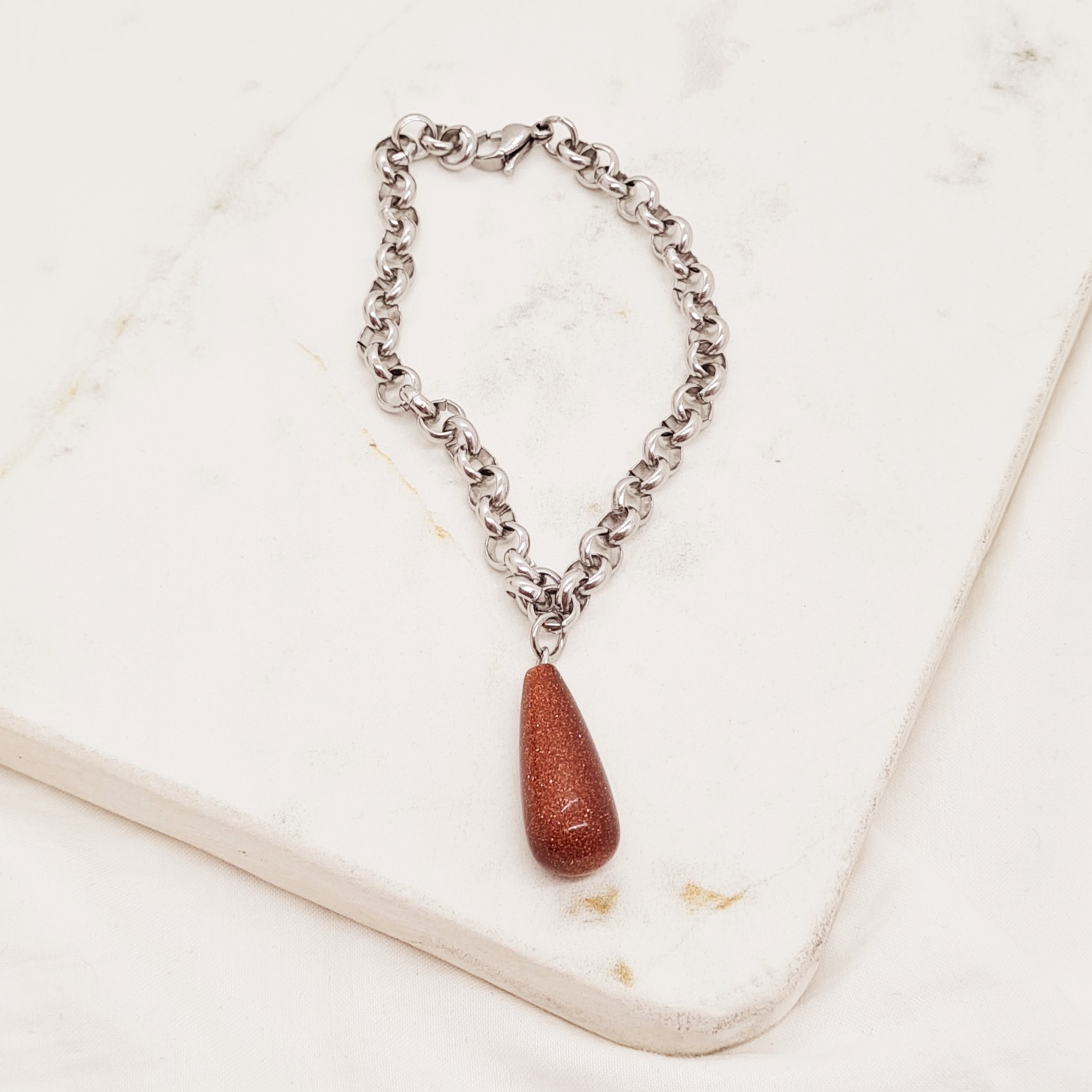 Imagen de producto PULSERA CON DIJE PIEDRA LLUVIA DE ORO - GOTA LARGA