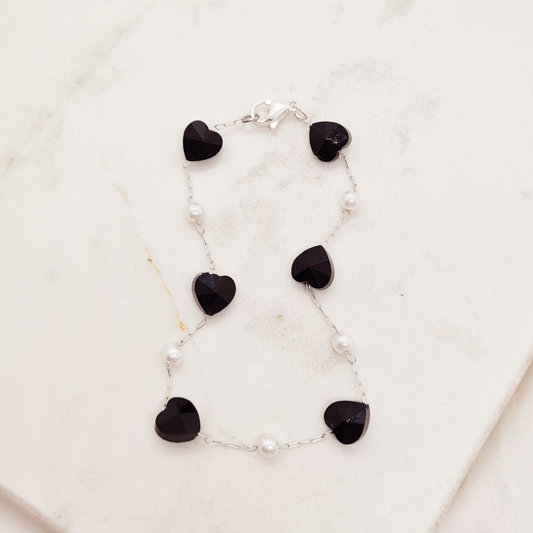 Imagen de producto PULSERA ACERO BLANCO FINA CON PERLITAS Y CORAZONES DE CRISTAL NEGRO