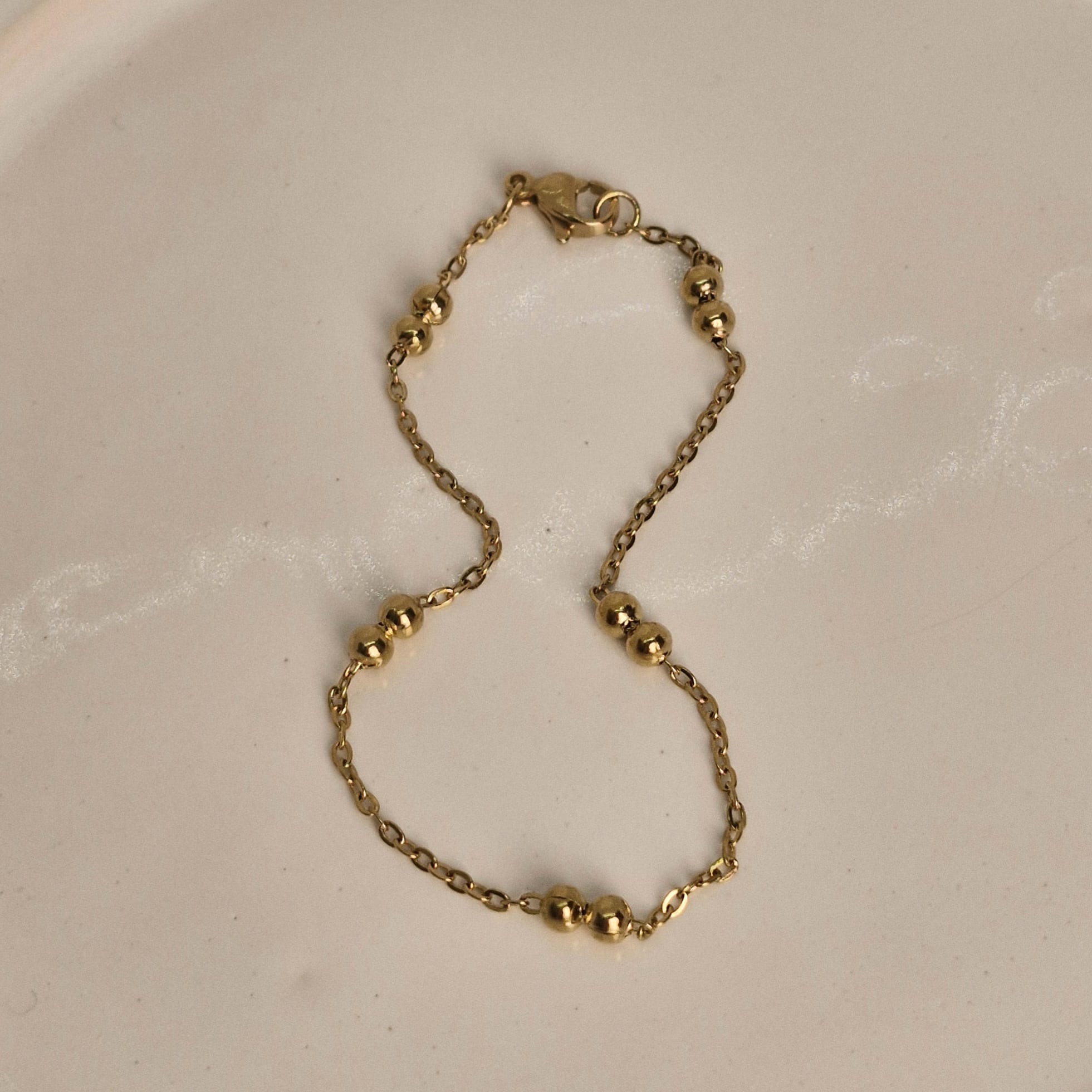 Imagen de producto PULSERA ACERO DORADO FINA CON DOBLE BOLITAS GRANDES
