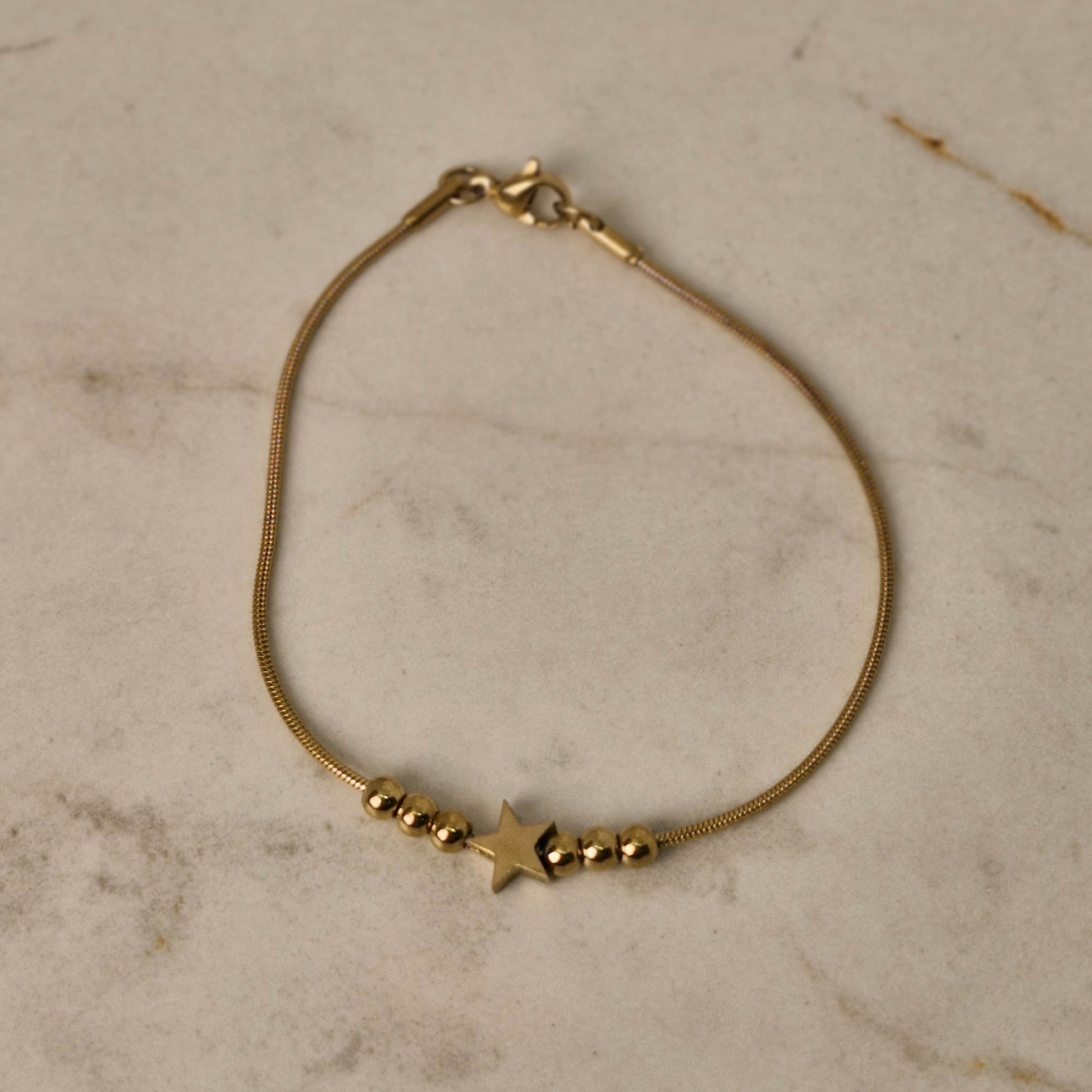 Imagen de producto PULSERA ACERO DORADO COLITA DE RATA CON BOLITAS Y ESTRELLA