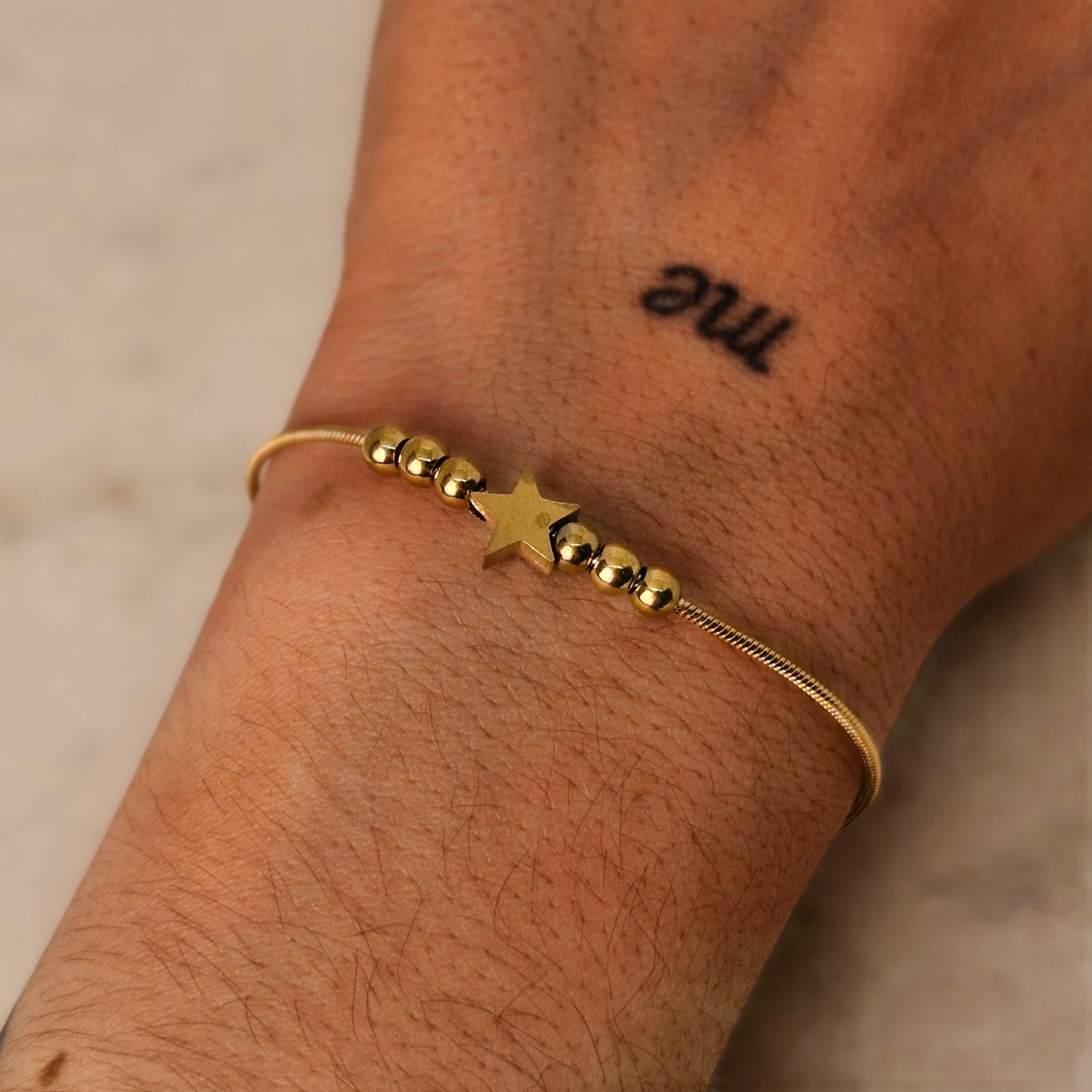 Imagen de producto PULSERA ACERO DORADO COLITA DE RATA CON BOLITAS Y ESTRELLA