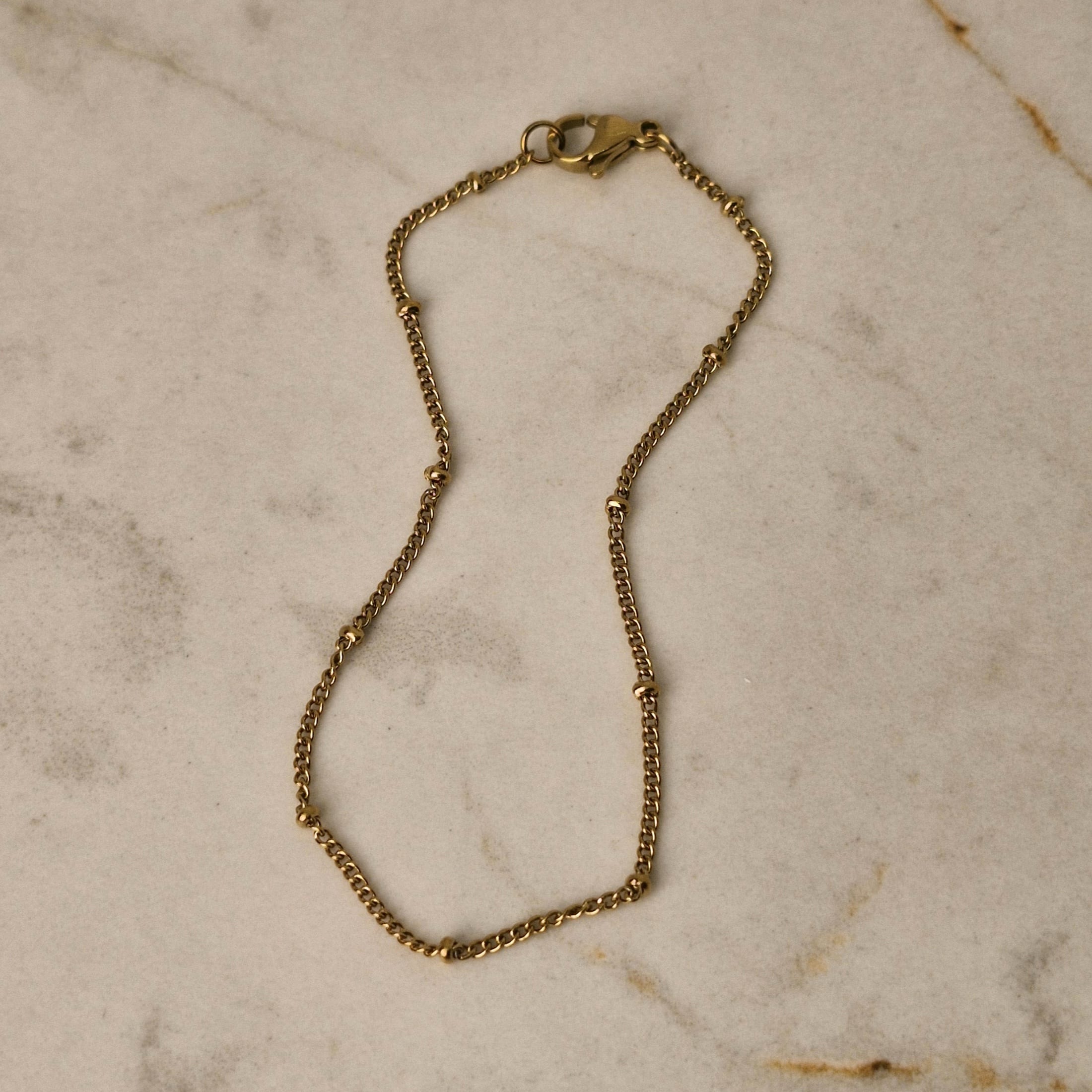 Imagen de producto PULSERA ACERO DORADO FINA PLANA CON BOLITAS CHICAS