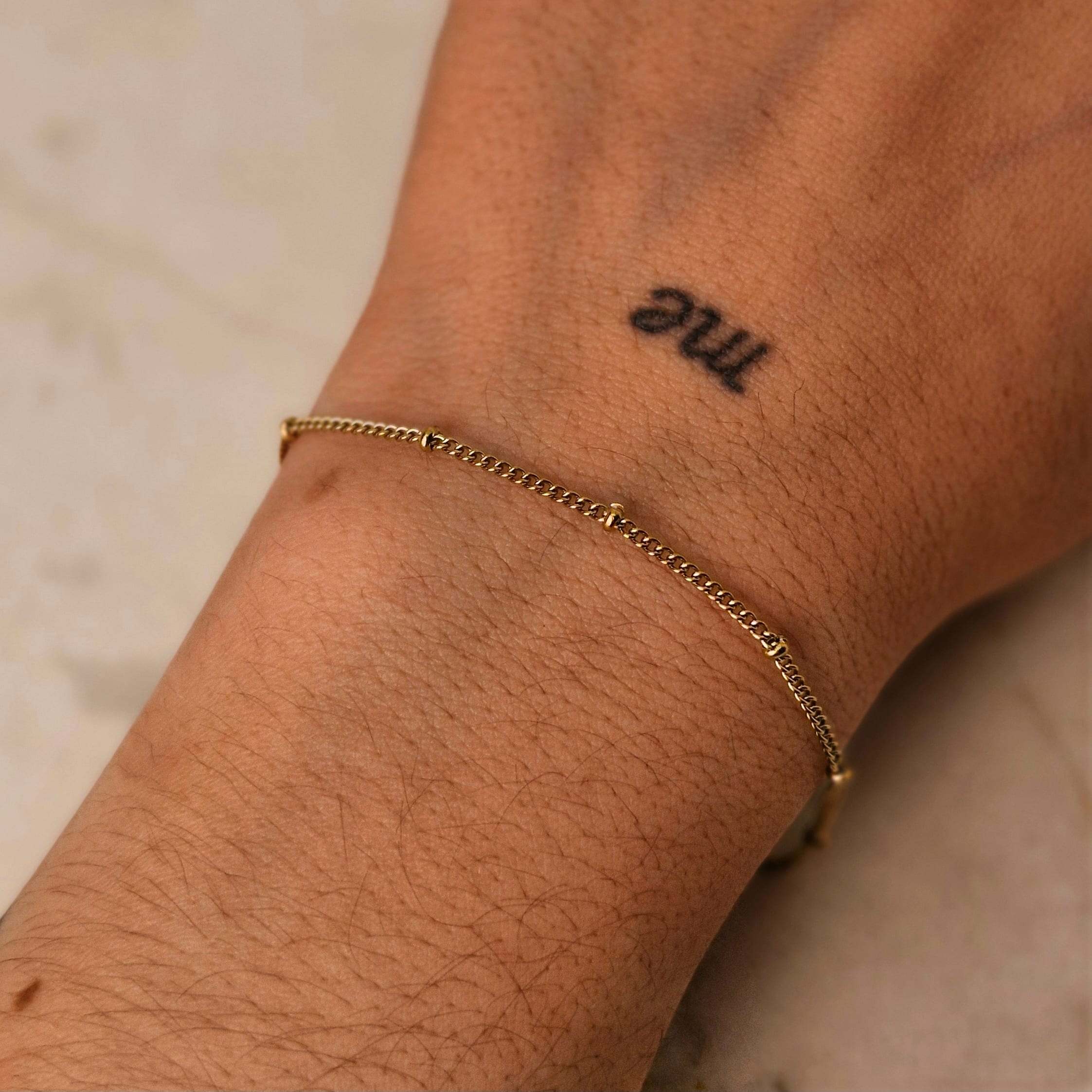 Imagen de producto PULSERA ACERO DORADO FINA PLANA CON BOLITAS CHICAS