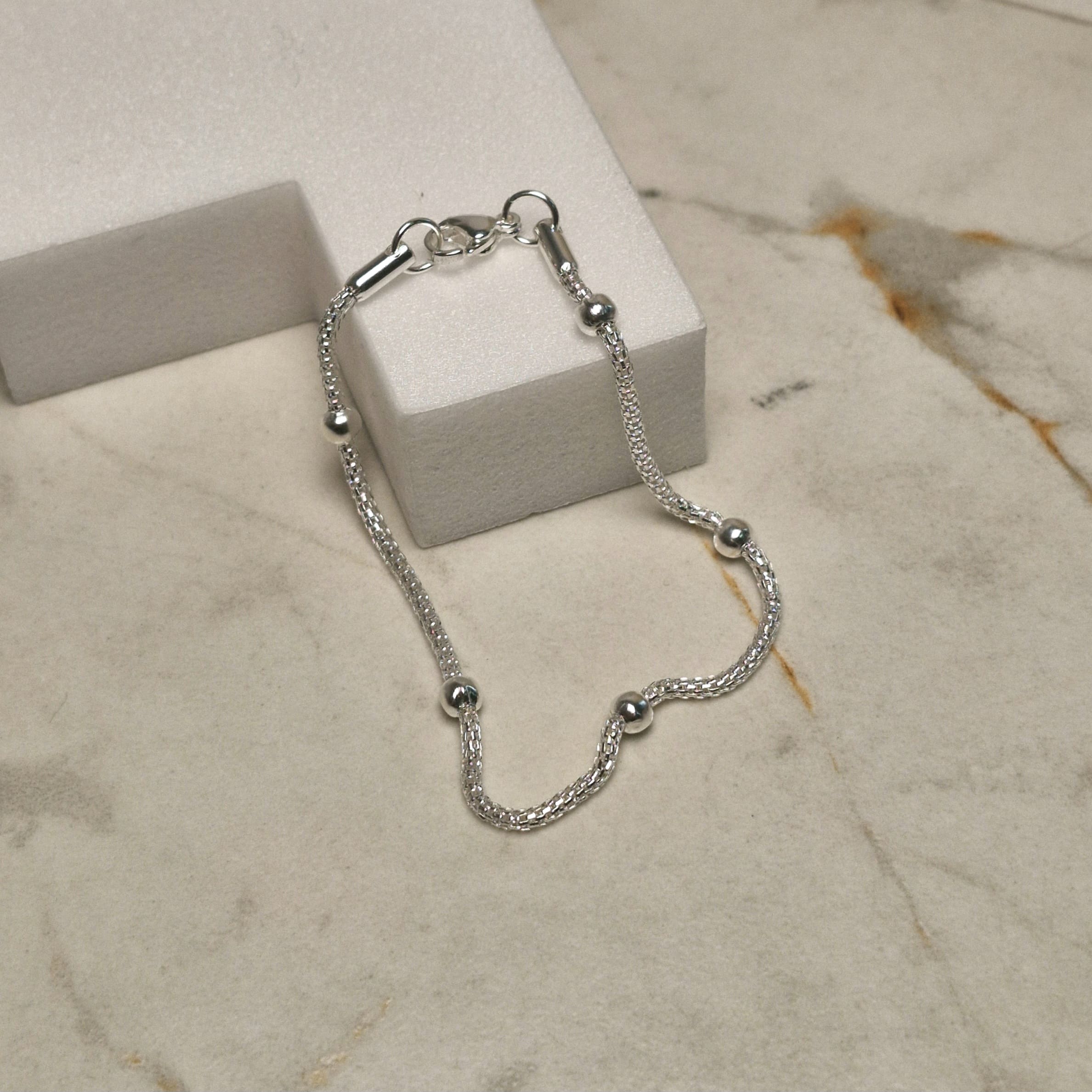 Imagen de producto PULSERA ACERO BLANCO COREANA CON BOLITAS