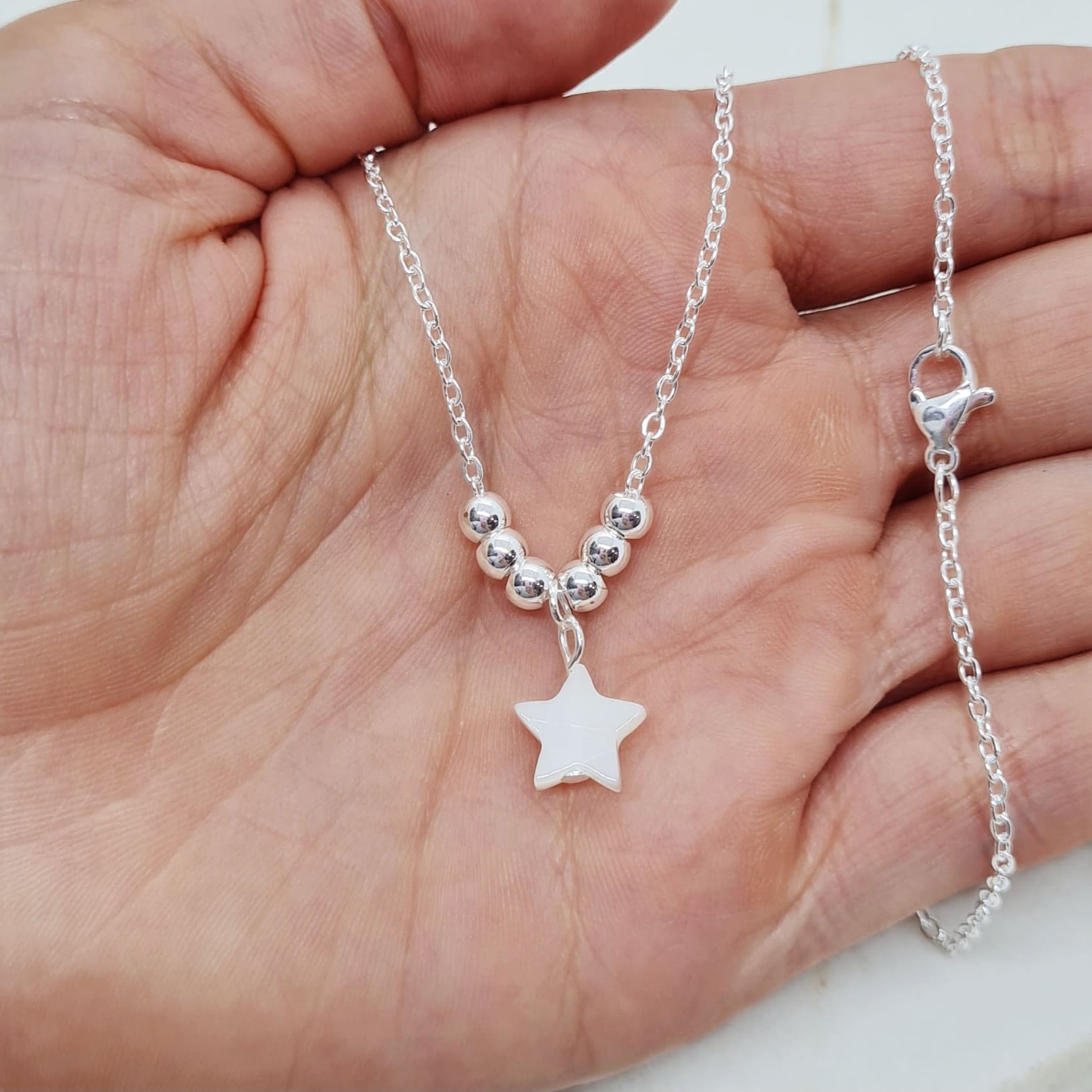 Imagen de producto COLLAR ACERO BLANCO CON BOLITAS Y DIJE NACAR - ESTRELLA